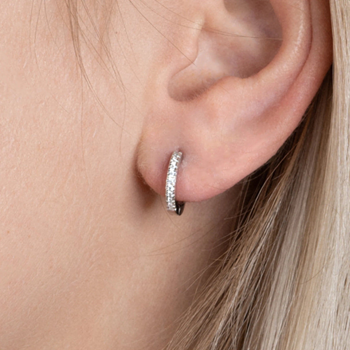 Boucles d’oreilles mini créoles 11 mm pavées de zircons en argent 925, portées par une femme