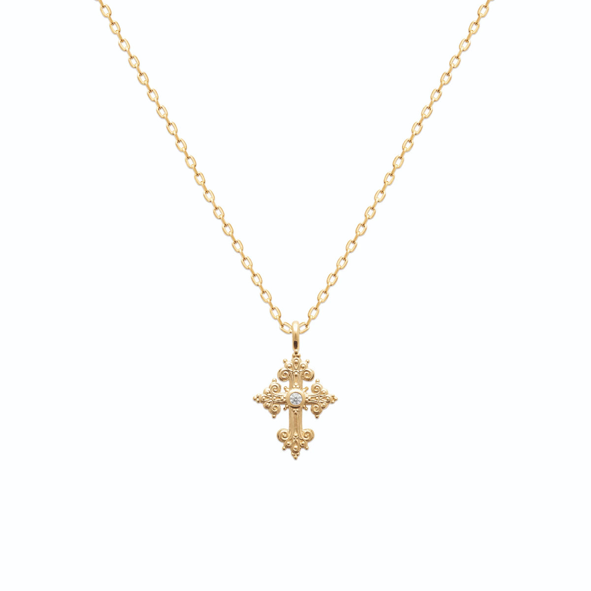 Pendentif croix fleurdelisée ouvragée sertie d’un zircon en plaqué or vu de profil