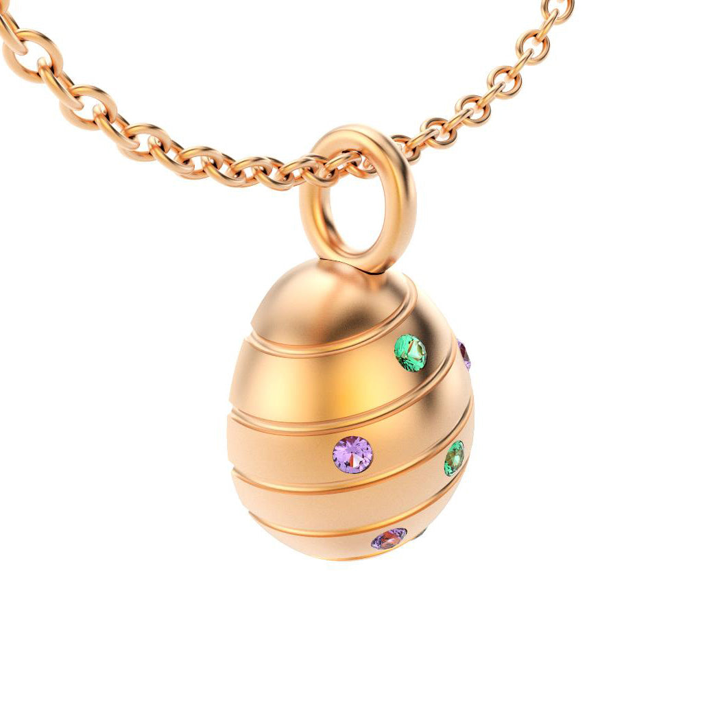 pendentif oeuf pour femme en or rose avec saphirs violets et emeraude