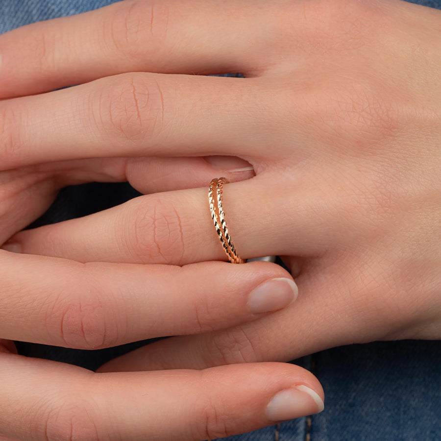 Bague anneau torsadé et petite bille d’or coulissante en plaqué or, portée à la main