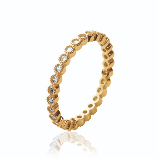 Bague anneau serti tout autour de petits zircons en collerettes perlées en plaqué or, vue de trois quarts