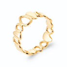 Bague bandeau ajouré de cercles et gouttes façon galets en plaqué or, vue de trois quarts