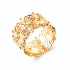 Bague bandeau large ajouré de fleurs en filigrane en plaqué or, vue de trois quarts
