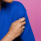 Bague demi-soleil de grains d’or et zircon au sommet plaqué or portée à la main