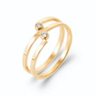 Bague double anneau spirale ouverte et deux zircons décalés en plaqué or, vue de trois quarts