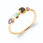 Bague fine ligne de quatre pierres violette, vert d’eau, vert olive et rose en plaqué or, vue de trois quarts