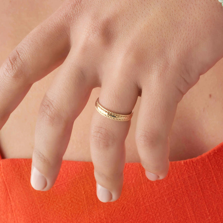 Bague jonc ouvert rangs perlés et côtelés alternés en plaqué or, portée à la main
