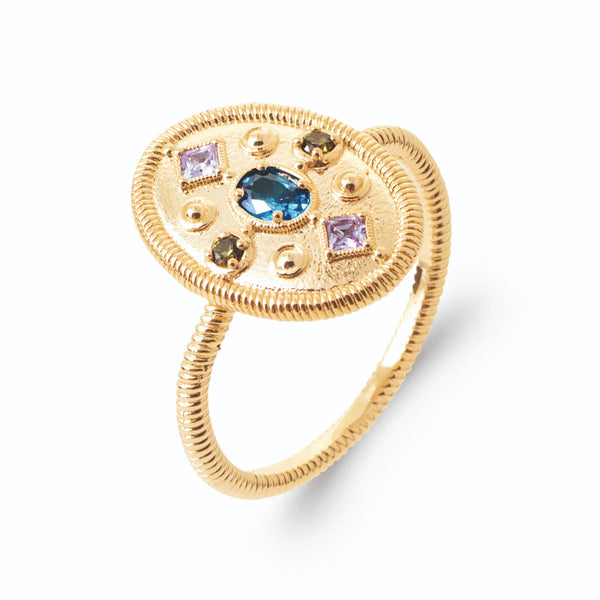 Bague médaillon ovale cordé pierre bleu profond et pierres en croix en plaqué or, vue de trois quarts