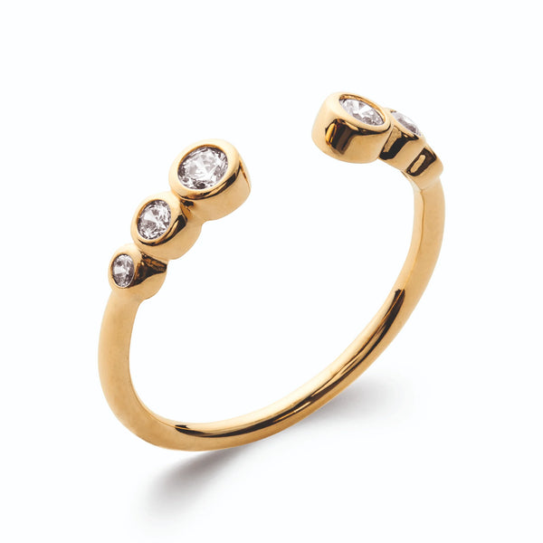 Bague ouverte deux extrémités à deux petits zircons sertis clos en plaqué or, vue de trois quarts