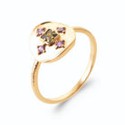 Bague pastille martelée et croix de pierres vertes et violettes en plaqué or, vue de trois quarts