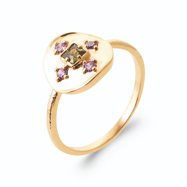 Bague pastille martelée et croix de pierres vertes et violettes en plaqué or, vue de trois quarts