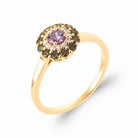 Bague rosette pierre violette, zircons et pierres vert foncé en plaqué or, vue de trois quarts
