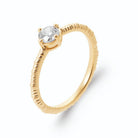 Bague solitaire zircon rond quatre griffes sur anneau strié en plaqué or
