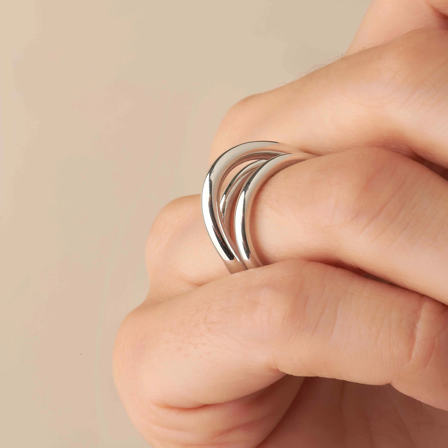 Bague trois anneaux croisés en argent rhodié, portée à la main