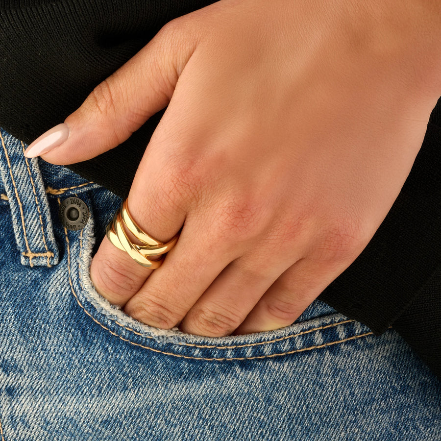 Bague trois larges joncs polis croisés en X en plaqué or, portée à la main