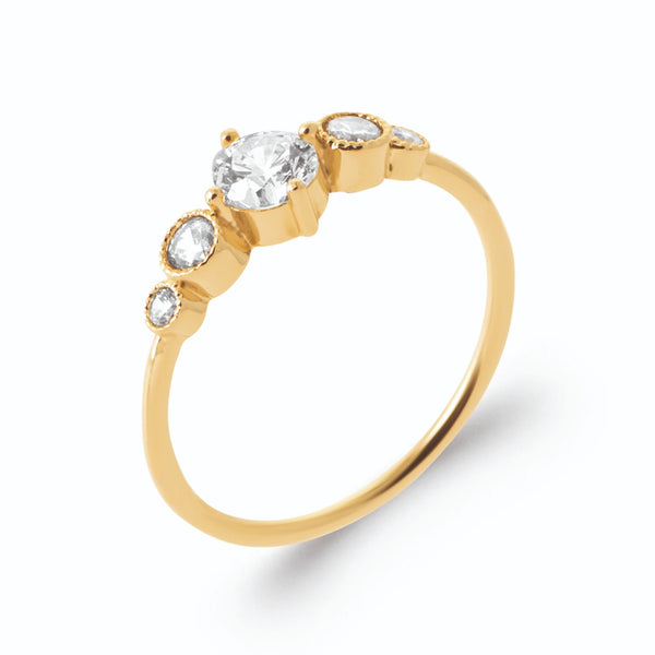 Bague zircon central griffes et quatre zircons sertis clos en plaqué or, vue de trois quarts
