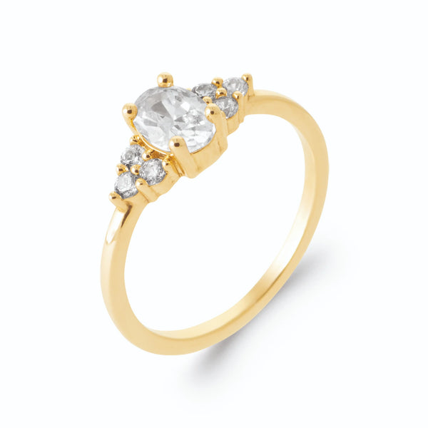 Bague zircon ovale blanc et trios de zircons en plaqué or, vue de trois quarts