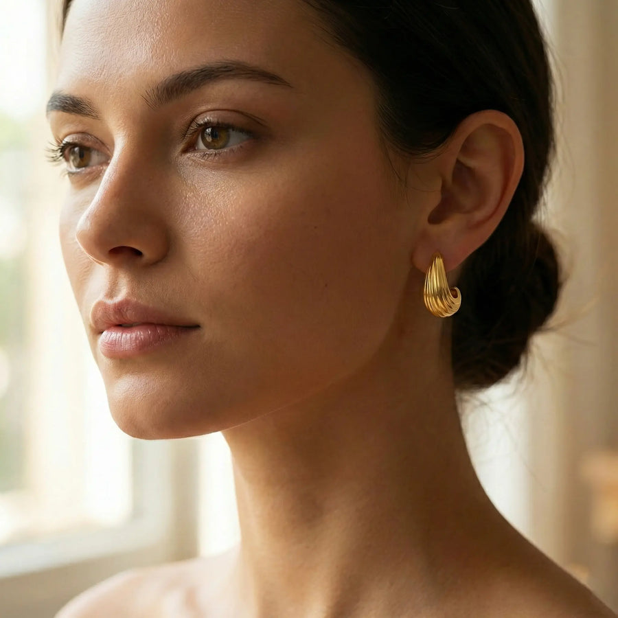 Boucles d’Oreilles Créoles Nervurées en PVD Doré – L’Éclat Sculptural au Quotidien, portées à l’oreille