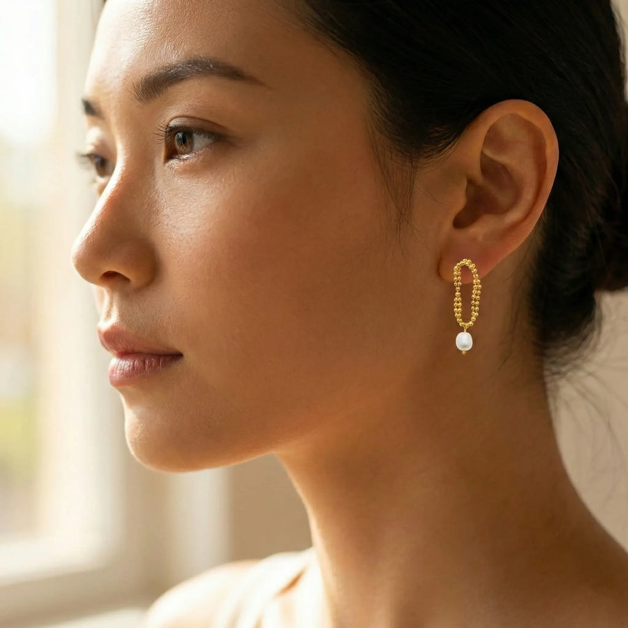 Boucles d’Oreilles Perlées et Goutte Nacrée en PVD Doré – L’Éclat Suspendu, portées à l’oreille