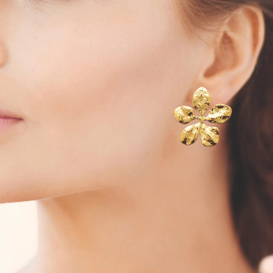 Boucles d’oreilles fleur martelée en acier PVD doré, portées à l’oreille