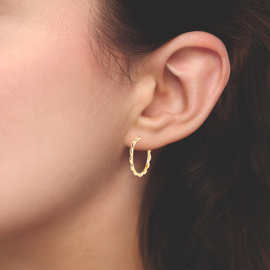 Boucles d’oreilles créoles festonnées grand modèle en plaqué or, portées à l’oreille