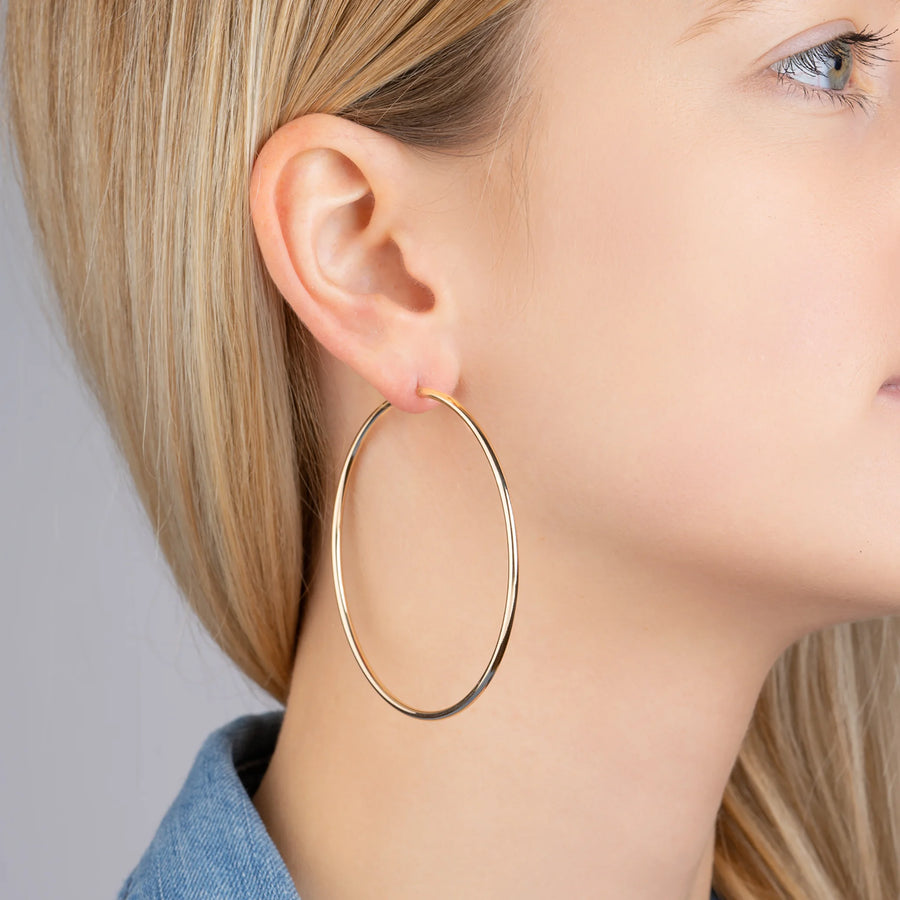 Boucles d’oreilles grandes créoles 60 mm en plaqué or, portées à l’oreille