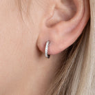 Boucles d’oreilles mini créoles 11 mm pavées de zircons en argent 925, portées par une femme