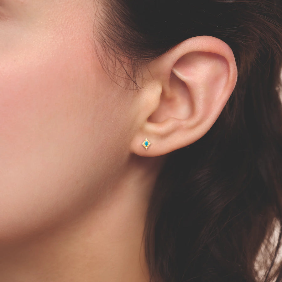 Boucles d’oreilles pendantes losange granité et cabochon turquoise en plaqué or, portées à l’oreille