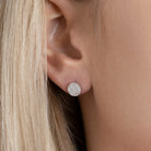 Boucles d’oreilles puces disque pavé de zircons en argent 925, portées par une femme