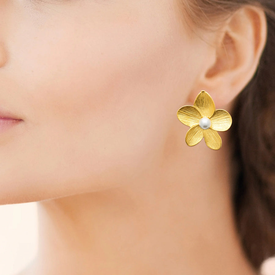 Boucles d’oreilles puces fleur de frangipanier et perle en acier PVD doré, portées à l’oreille