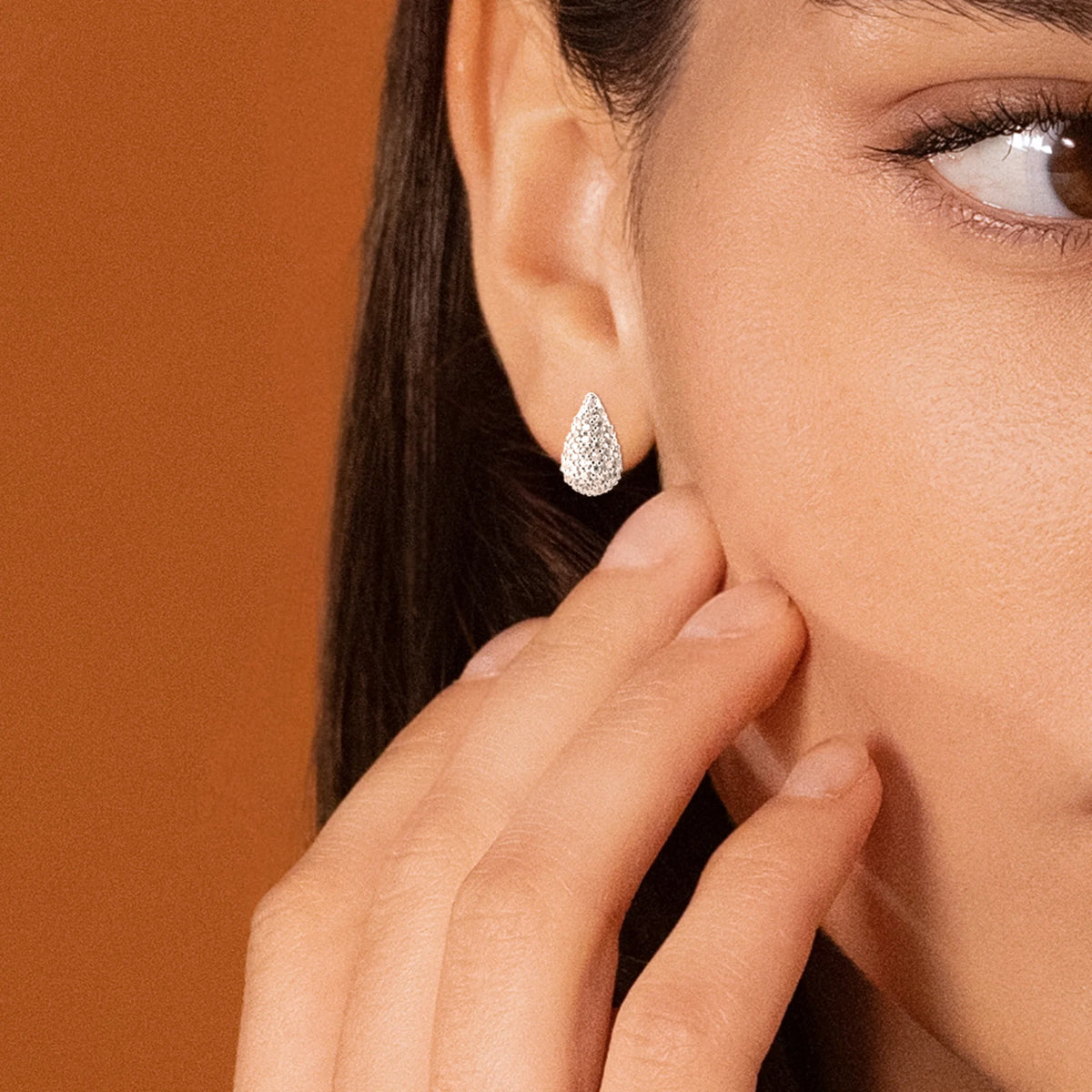 Boucles d’oreilles puces gouttes bombées pavées de zircons en argent 925, portées par une femme