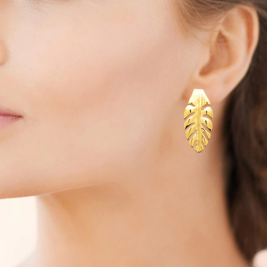 Boucles d’oreilles puces longue feuille nervurée en acier PVD doré, portées à l’oreille