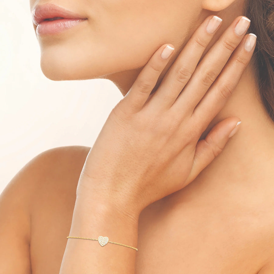 Bracelet chaîne cœur pavé de zircons en plaqué or, porté au poignet