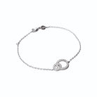 Bracelet deux anneaux entrelacés dont un pavé de zircons en argent 925, vue d’ensemble sur fond blanc