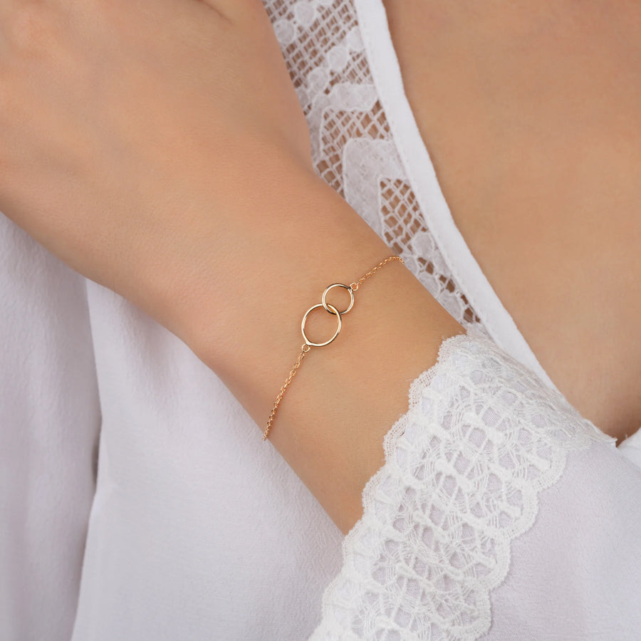 Bracelet double cercle entrelacé en plaqué or, porté au poignet