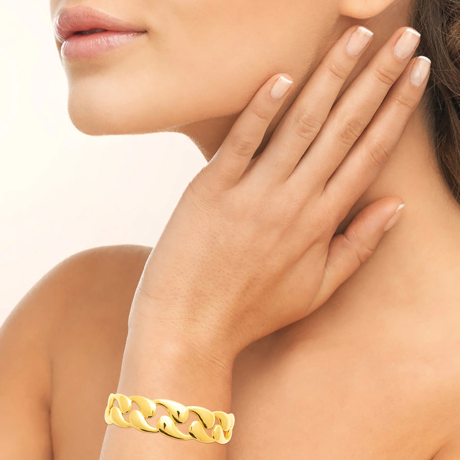 Bracelet jonc ouvert maille gourmette en acier PVD doré, porté au poignet