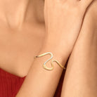 Bracelet jonc ouvert sinueux et zircons en plaqué or