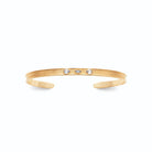 Bracelet jonc ouvert strié et trois pierres bleutées en plaqué or
