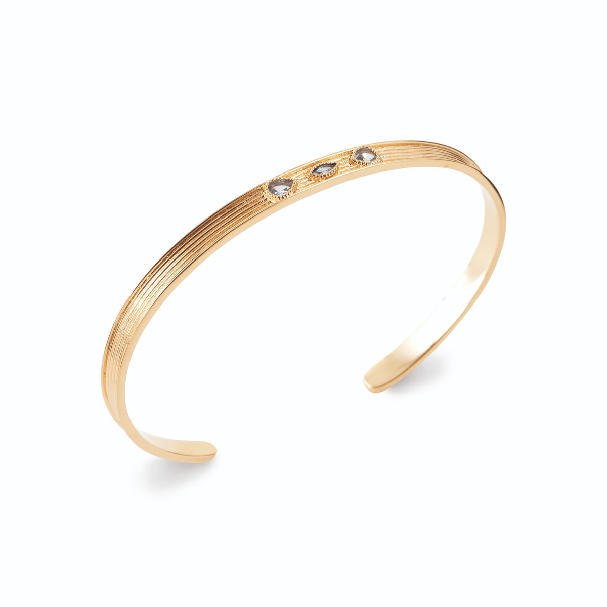 Bracelet jonc ouvert strié et trois pierres bleutées en plaqué or