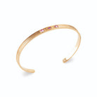 Bracelet jonc ouvert strié et trois pierres roses en plaqué or