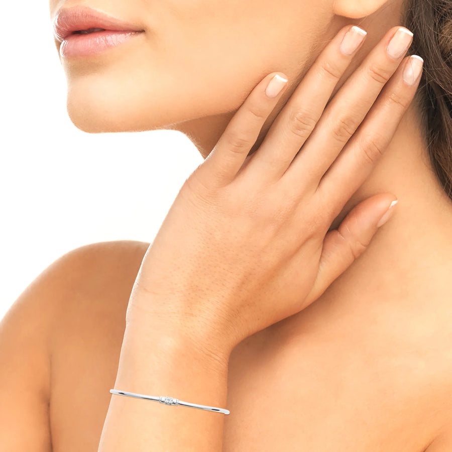 Bracelet jonc ouvert très fin à embout serti de zircons en argent 925 rhodié, porté au poignet