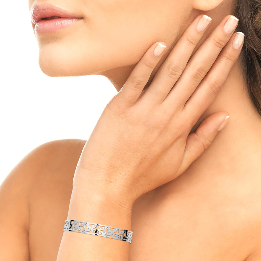 Bracelet manchette ajourée d’arabesques en acier inoxydable, porté au poignet