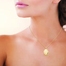 Collier galet doré au centre lisse et rayons striés en plaqué or