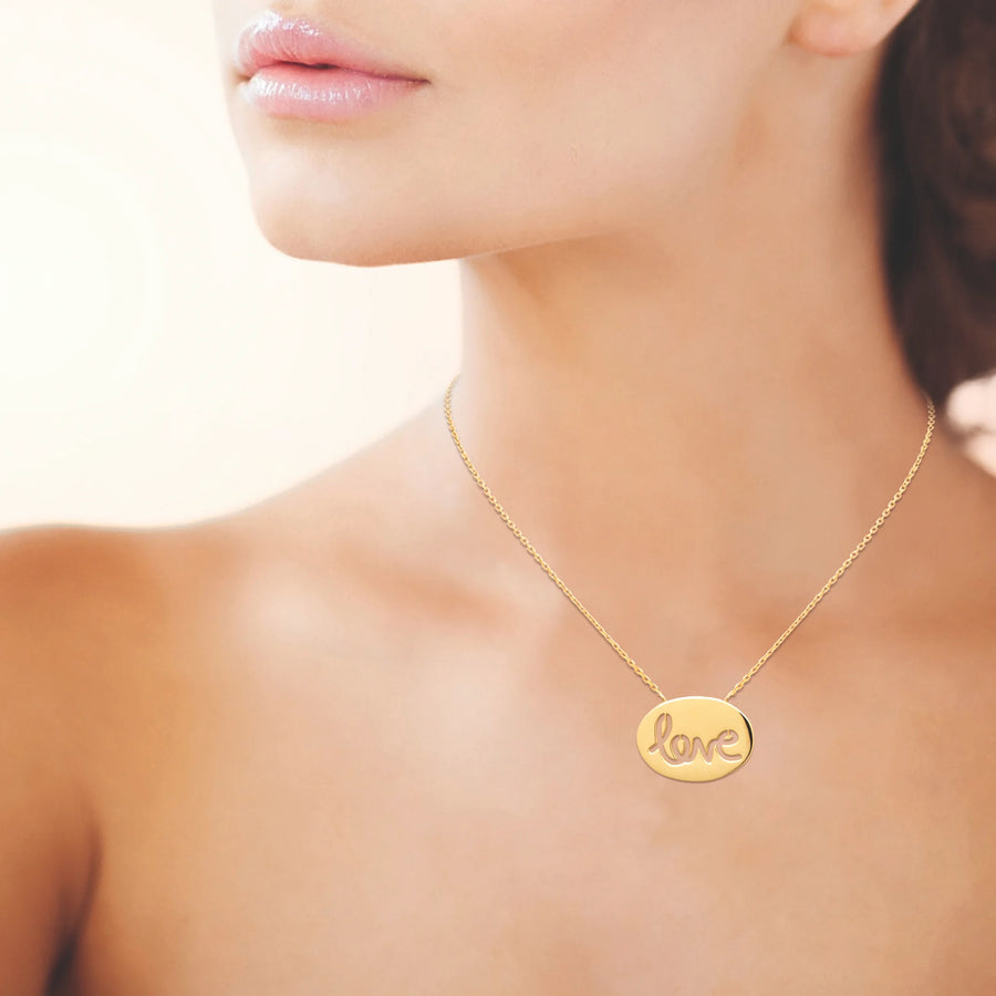 Collier médaille ovale ajourée du mot love en plaqué or, porté