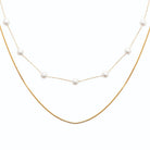 Collier double rang perles espacées et chaîne serpent en acier doré
