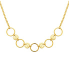 Collier plastron d’anneaux lisses et pastilles martelées en acier doré