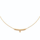 Collier chaîne fine à tubes granulés et perle de métal en plaqué or